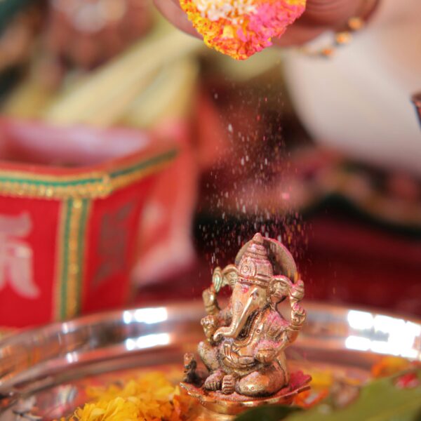 Colorful Ganesh pooja ritual with vibrant flowers and traditional offerings.